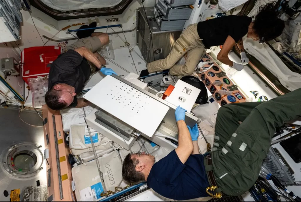 NASA astronauts Mike Barratt, Butch Wilmore, and Suni Williams are at work inside the International Space Station's Unity module.